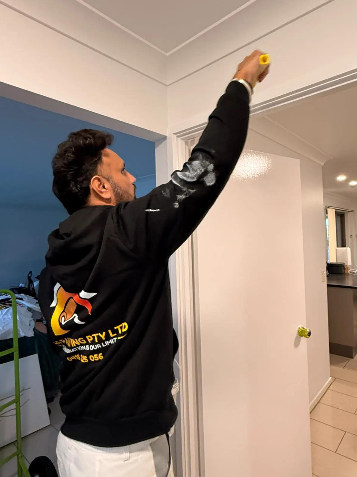 TAS Painting team member carefully cutting in a ceiling line during an interior repaint