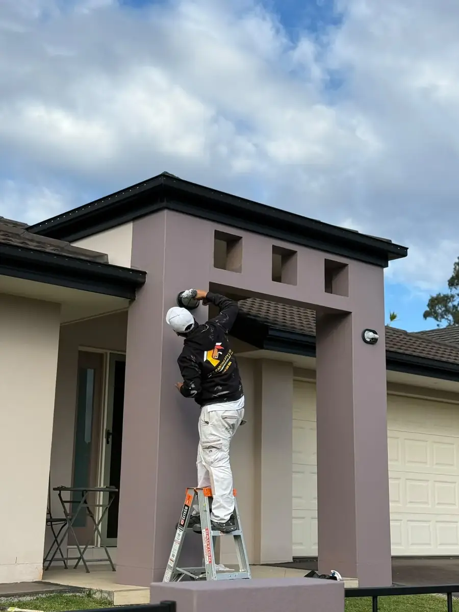 Painter cutting in an exterior feature wall and eaves detail