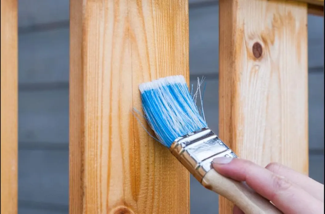 Close-up of a timber fence being painted