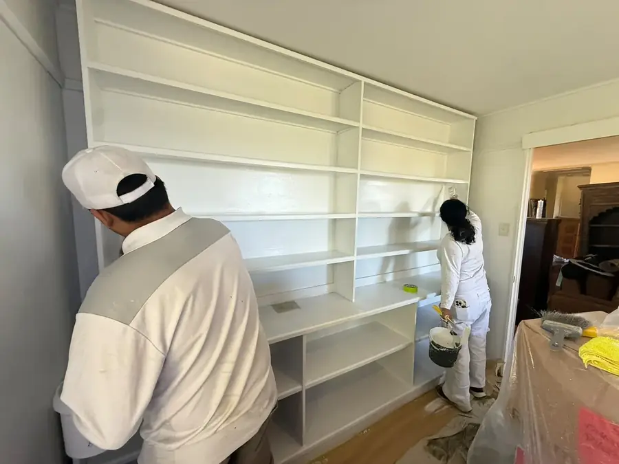 Painters respraying built-in cabinetry white